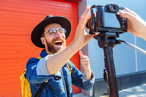 A man smiling as he takes a selfie with a camera, capturing a moment of joy and self-expression